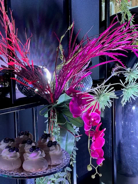 Elegancka dekoracja z różowymi orchideami, czerwonymi i zielonymi gałązkami, błyszczącymi kulami disco i babeczkami z kremem i jagodami w Hotelu Rubin koło Radomia