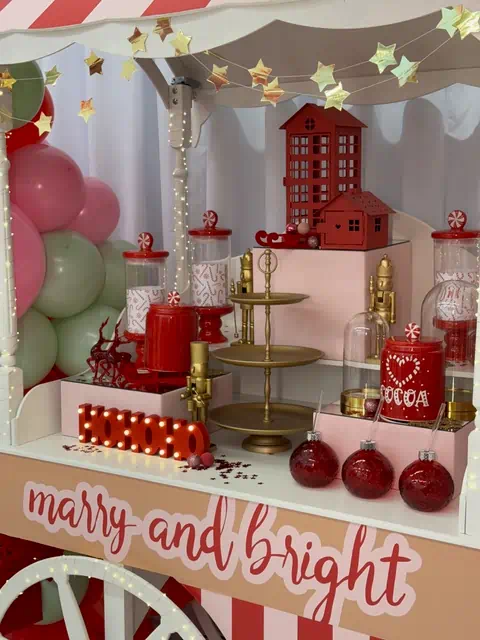 Świąteczna dekoracja stoiska z daszkiem, girlandą, elementami jak 'COCOA', cukierki, domki, bombki, figurki, balony i napis 'merry and bright' w Warszawie